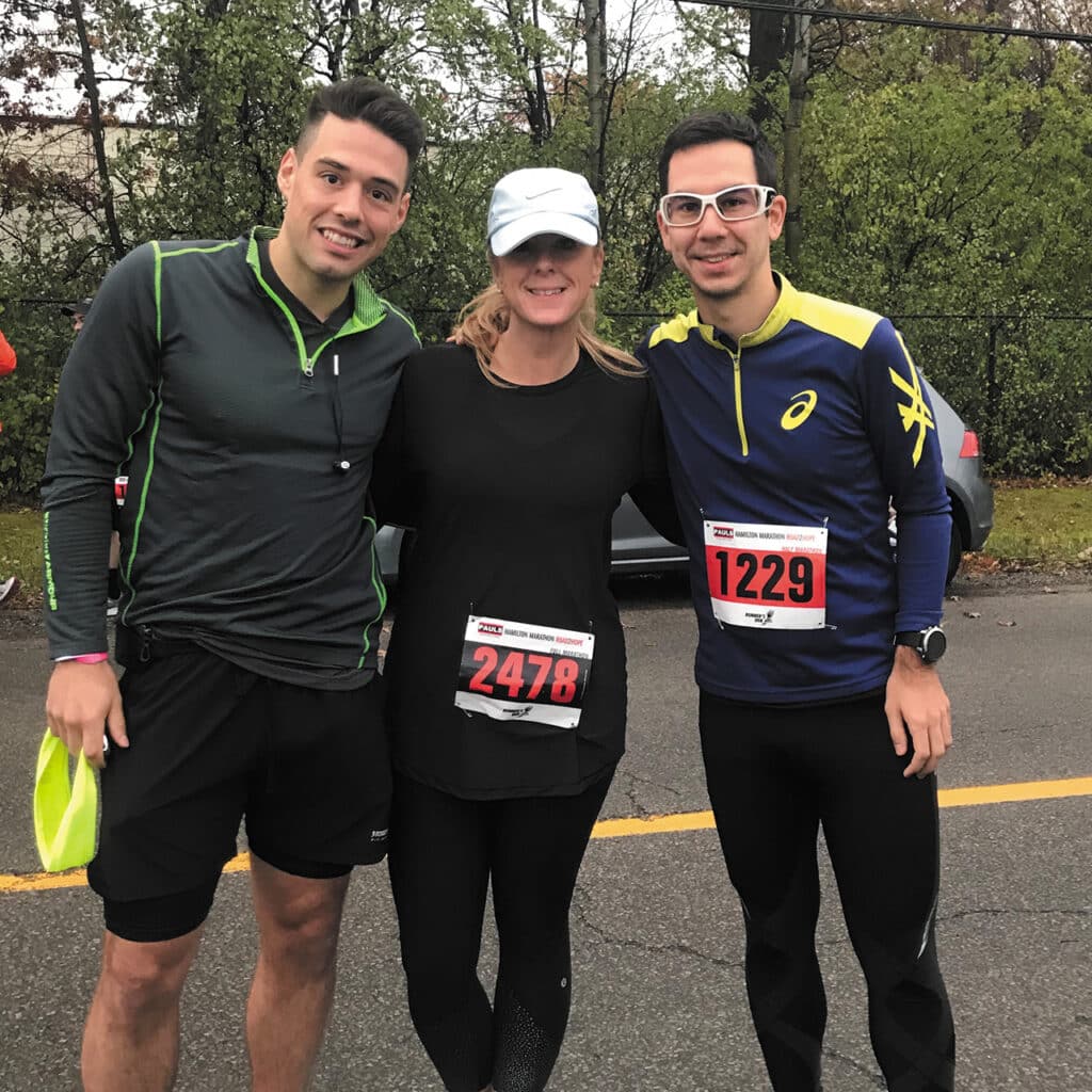 Kim Manias marathon running gear, standing between two other runners.